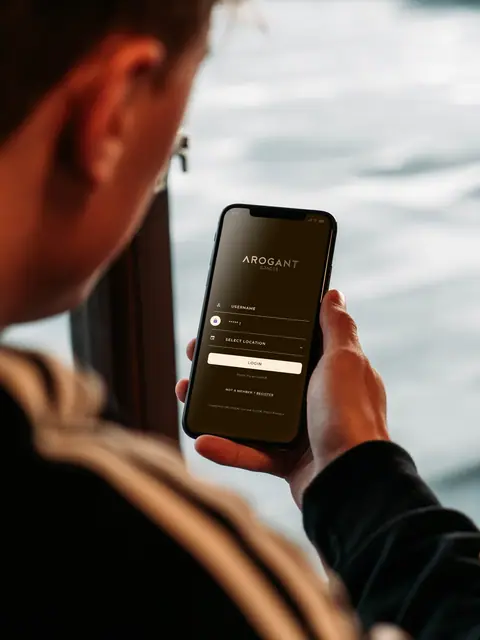 Hand holding a phone running the Arogant home-control app
