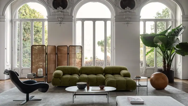 Living room with tall arched windows and a deep green sofa